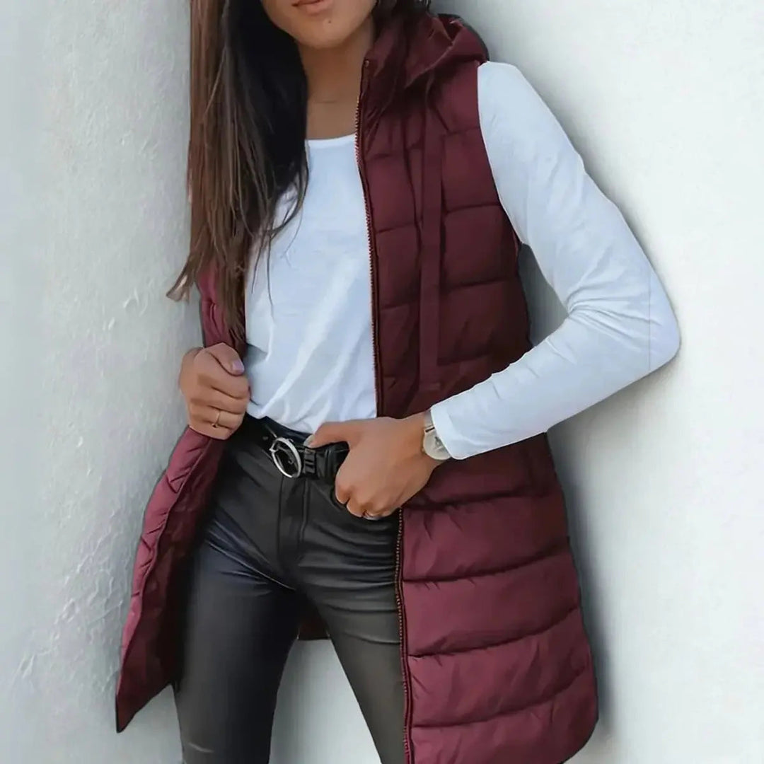 Trendy women's longline hooded puffer vest. Lightweight & sleeveless, essential for modern fall & winter layering.