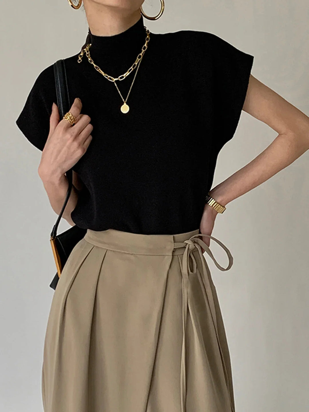 Women's chic mock-neck top with padded shoulders & cap-sleeves. Modern, versatile style.