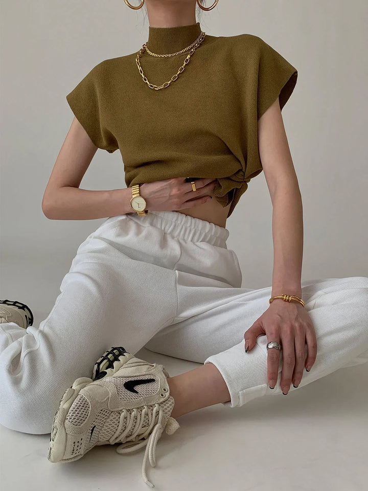 Versatile women's top: mock neck, padded shoulders, cap sleeves. Chic, sophisticated style.