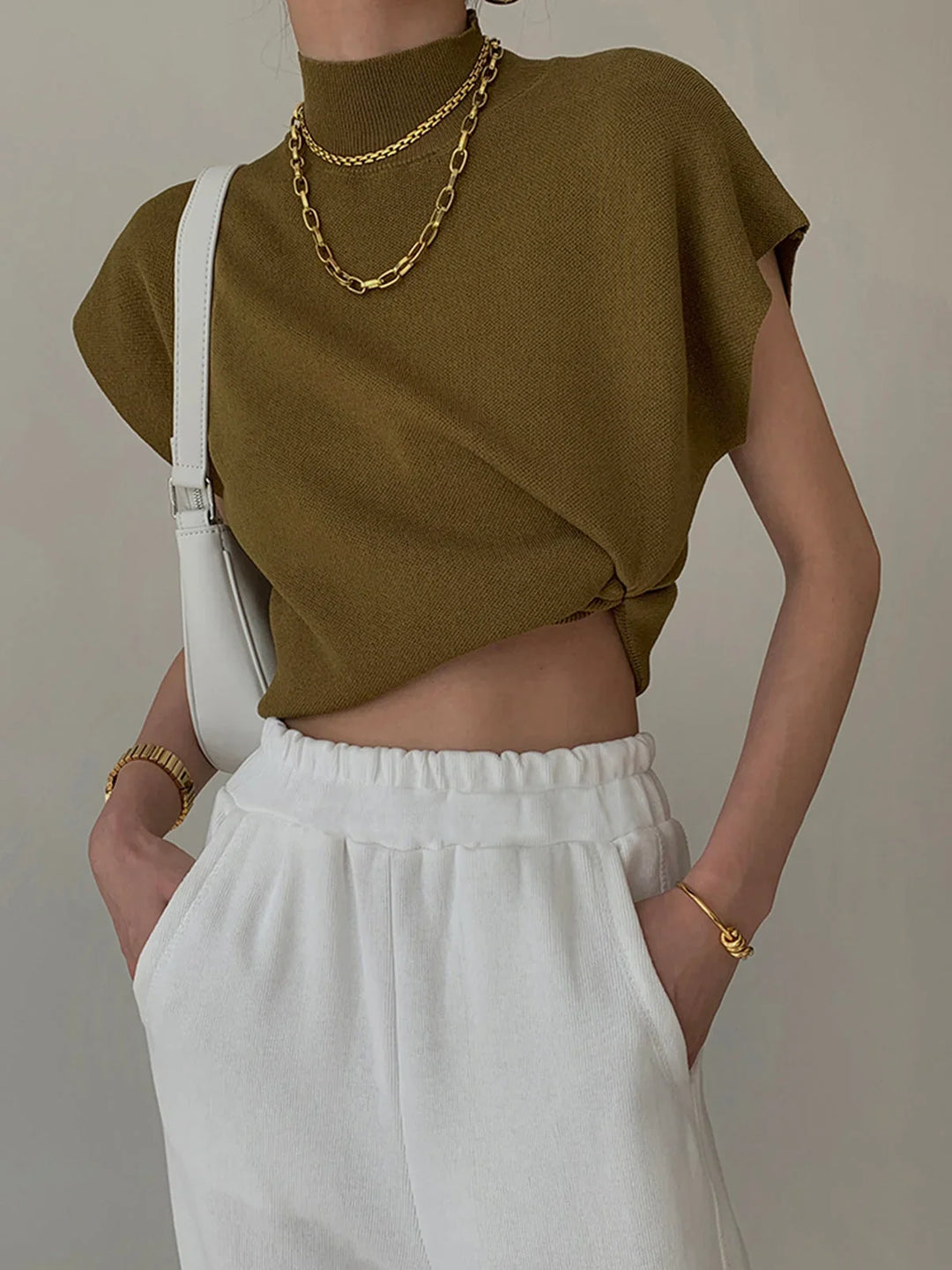 Sophisticated women's mock-neck top featuring padded shoulders & cap-sleeves. Chic design.
