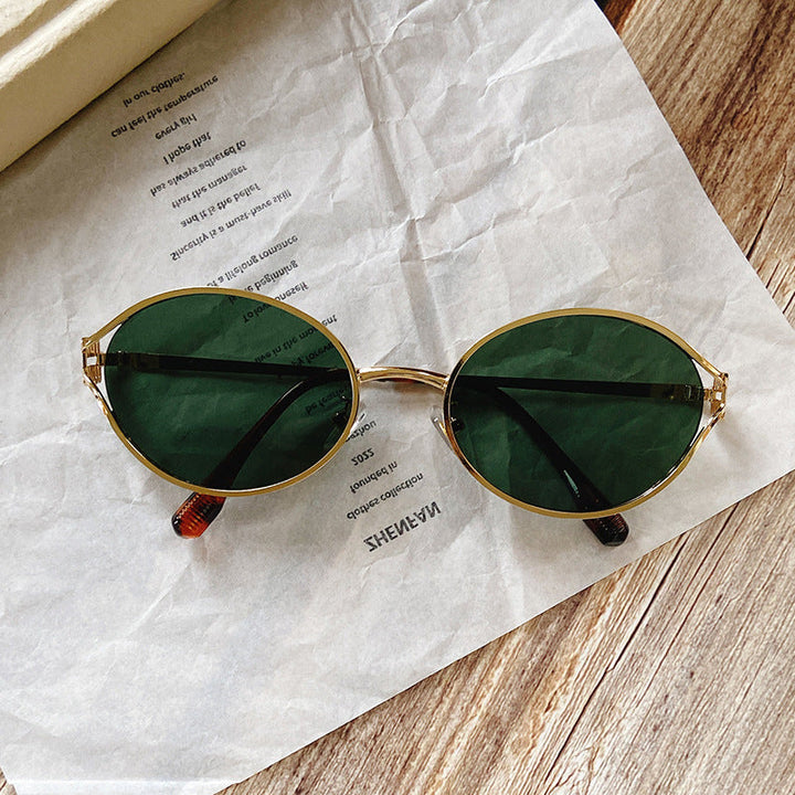 Elegant women's round sunglasses with intricate gold accents, a statement fashion accessory.