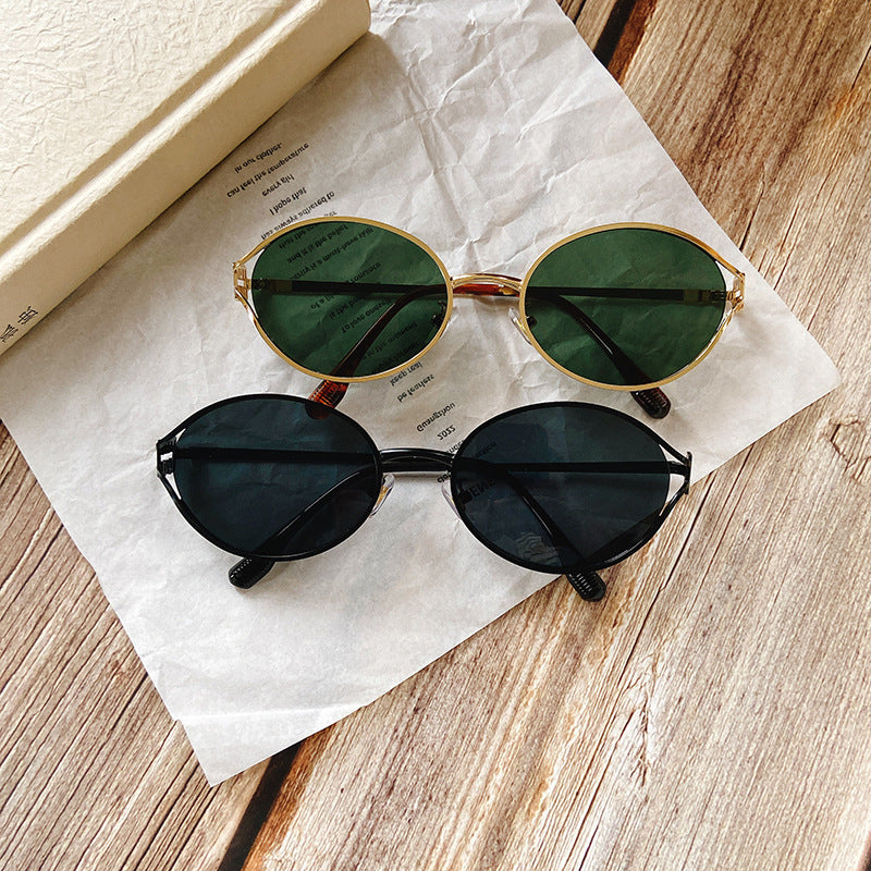 Close-up of women's round sunglasses showcasing stylish gold temple accents. Chic eye protection.