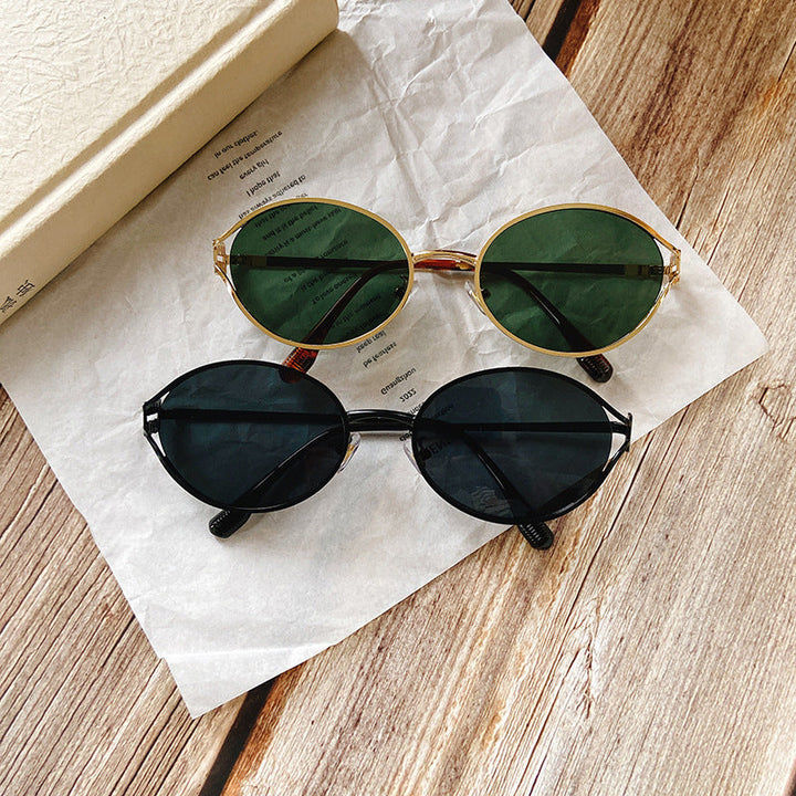 Close-up of women's round sunglasses showcasing stylish gold temple accents. Chic eye protection.
