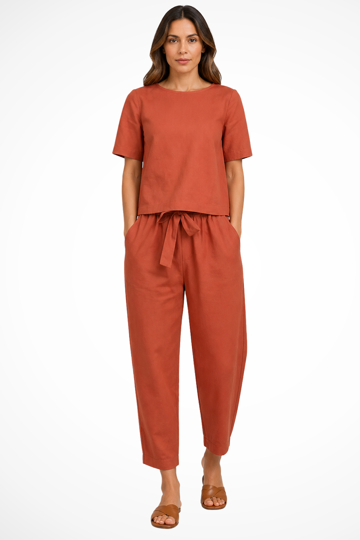Women's matching set: short sleeve crop top & tapered trousers. Comfortable, versatile two-piece outfit for summer chic.