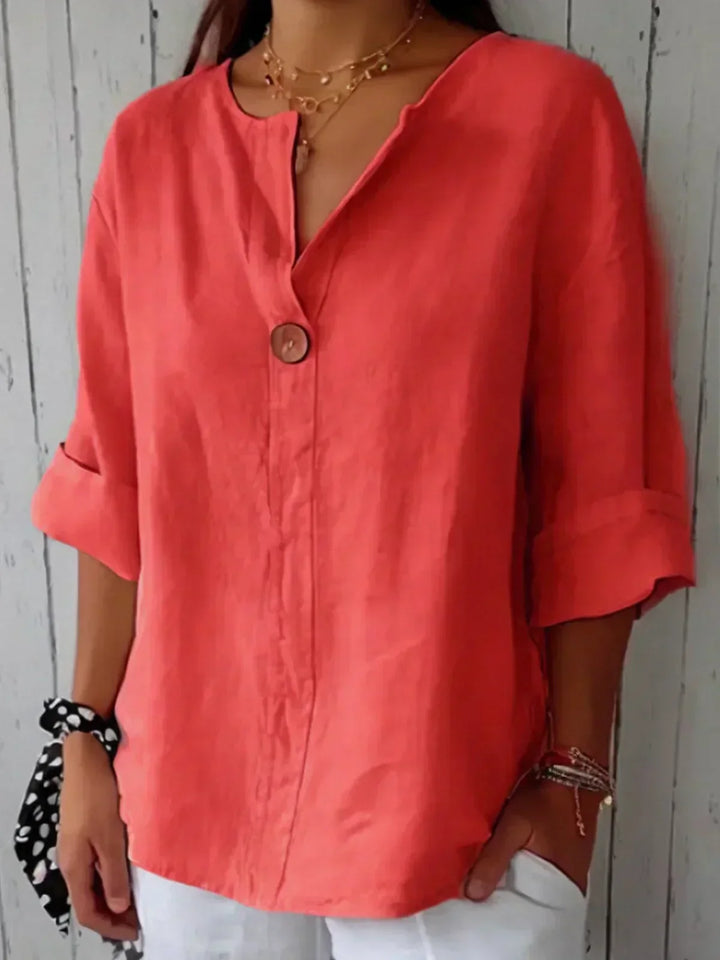 Woman wearing a stylish V-neck button-down blouse with roll sleeves, great for chic, versatile everyday looks.
