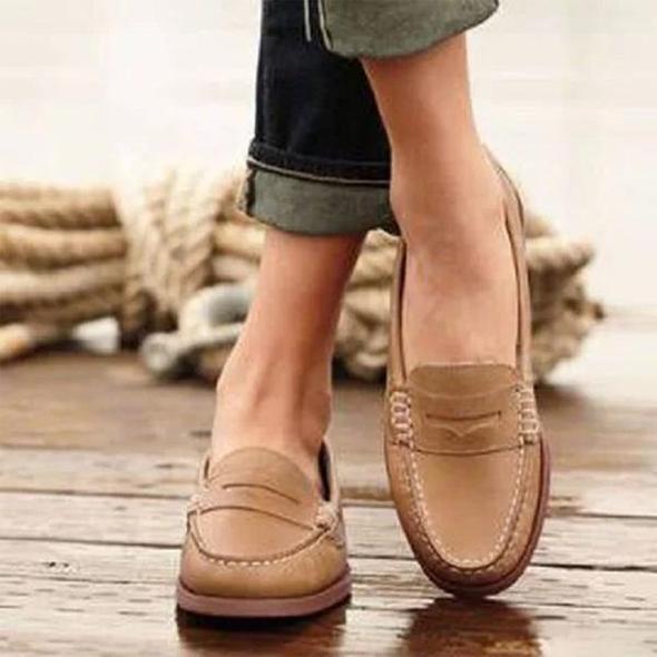 Elegant black slip-on penny loafers for women, featuring orthopedic comfort & classic design for work or daily wear.