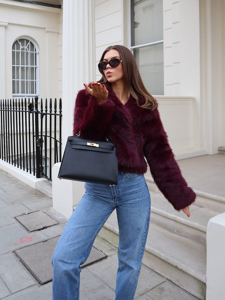 Chic women's faux fur coat, classic design. Elegant long-sleeve winter outerwear with a luxurious wide lapel.