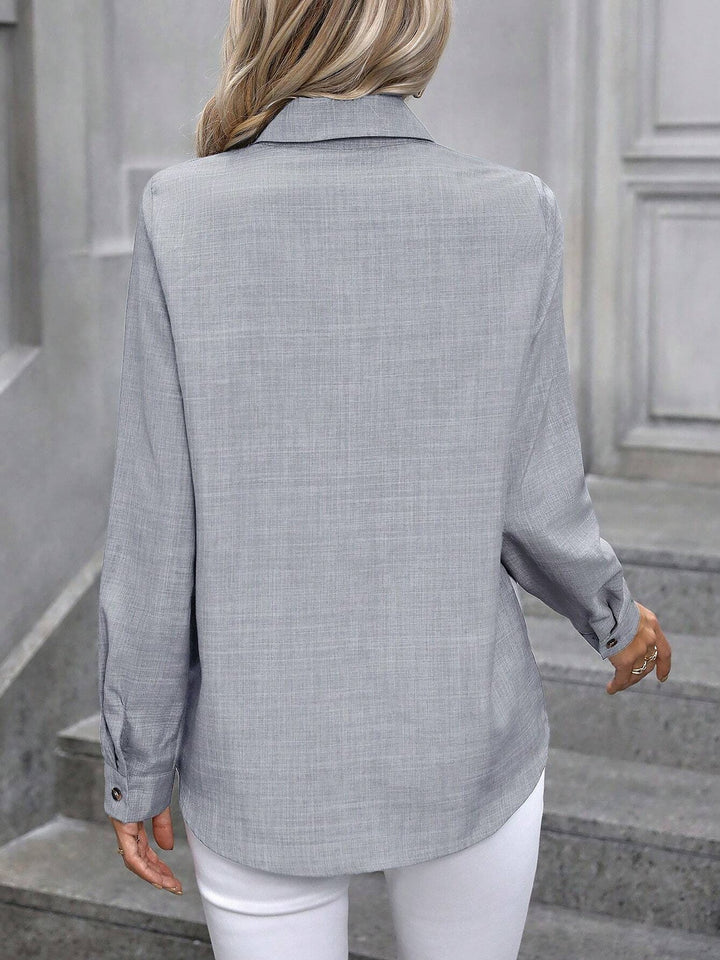 Professional women's button-up shirt, long sleeves, a crisp collared top for business.