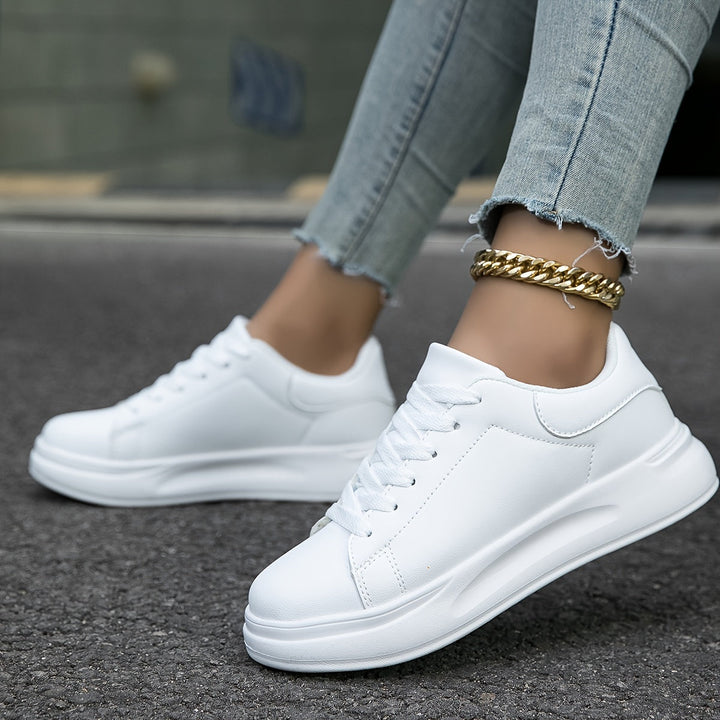 Women's versatile white footwear, combining casual comfort with a clean, chic low-top sneaker design.
