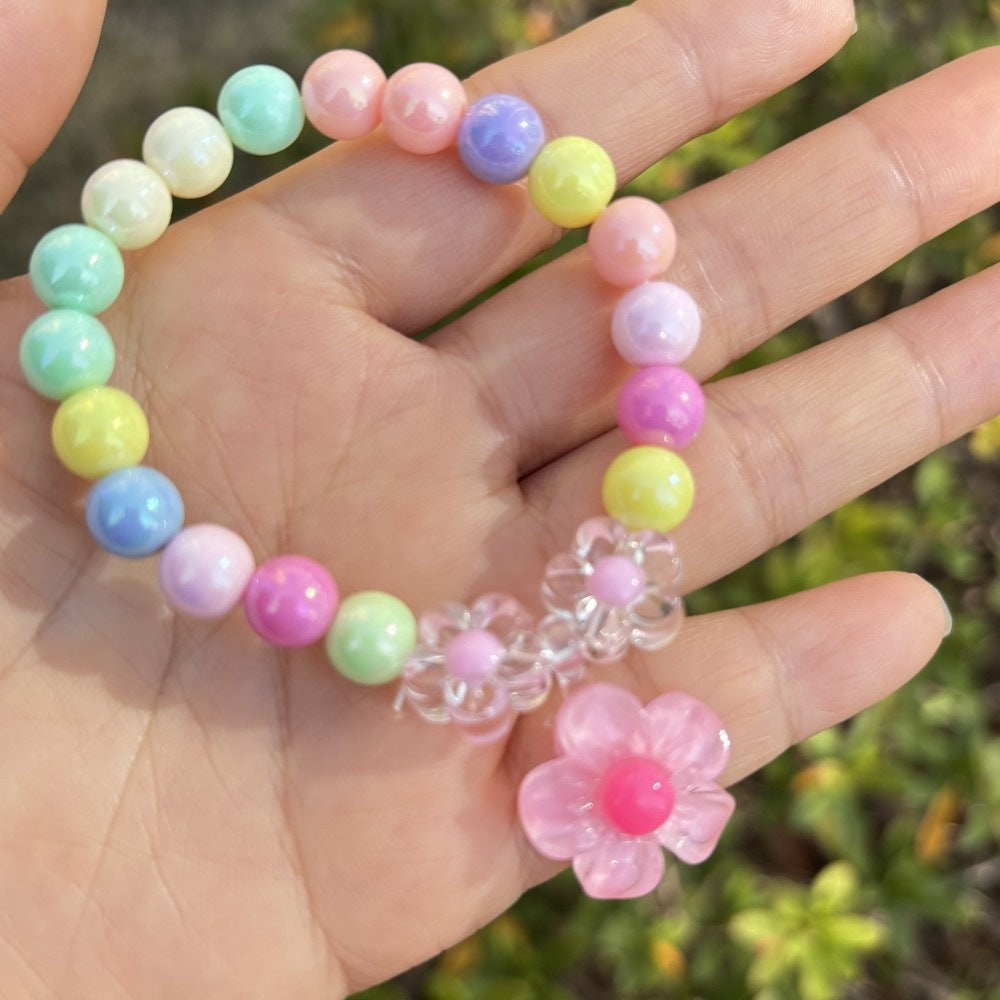 Women's plastic bead bracelet with whimsical colorful flower charms, a trendy gift.