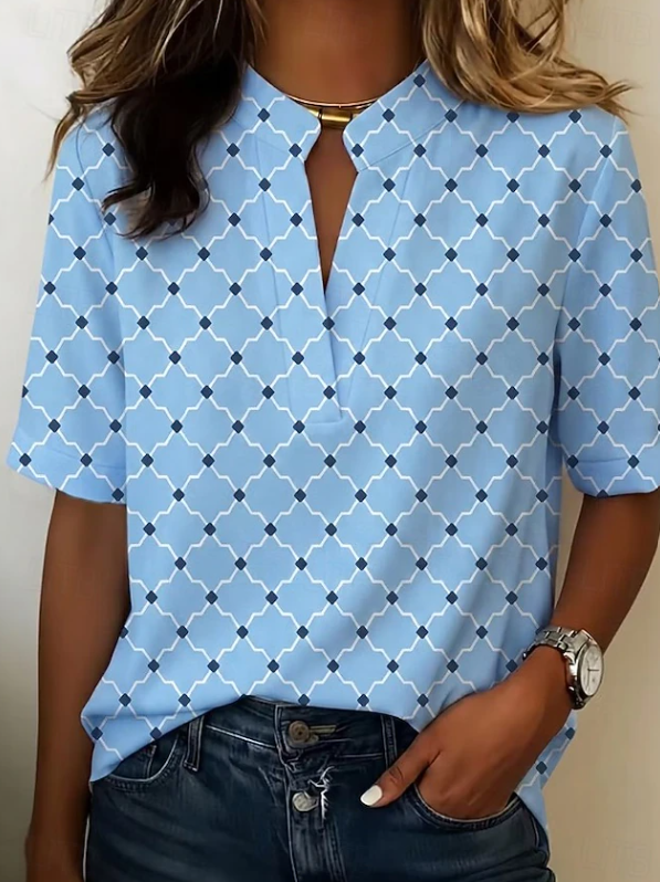 Woman wearing a vibrant geometric print Henley blouse, showcasing its relaxed fit & effortless style for casual spring/summer.