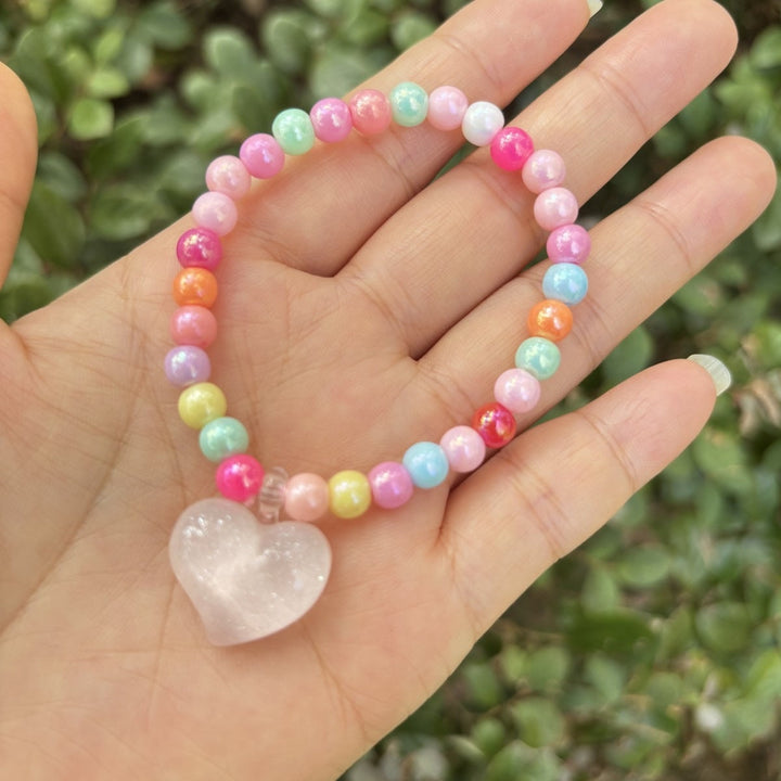 Close-up of vibrant multi-colored glass beads and a charming elephant charm on women's elastic bracelet.