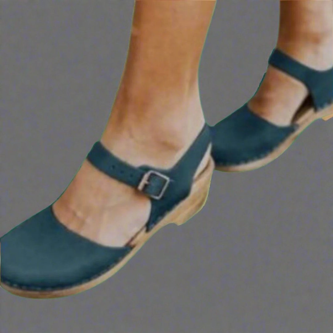 Retro women's platform clogs with a wooden sole, closed-toe design & secure ankle strap for everyday fashion.