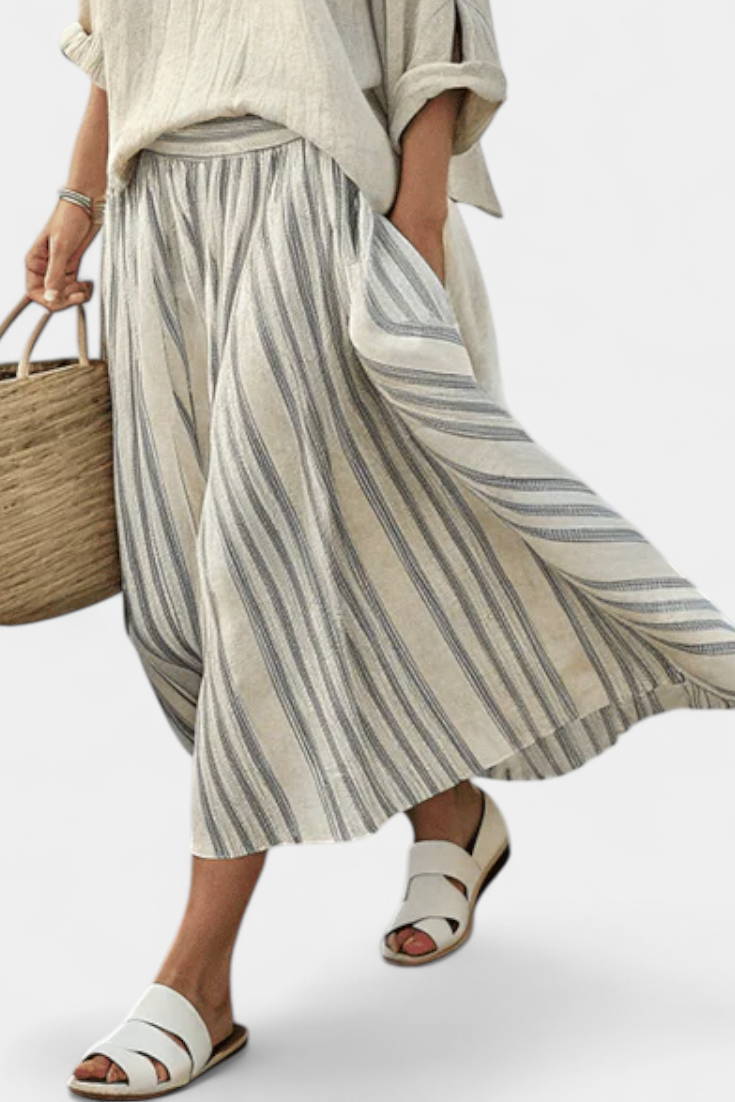 Stylish women's beige loose top & striped midi skirt set. A comfortable and versatile casual outfit for summer fashion.