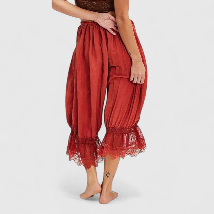 Close-up of intricate patchwork lace detailing on comfortable women's mid-rise trousers, unique design.