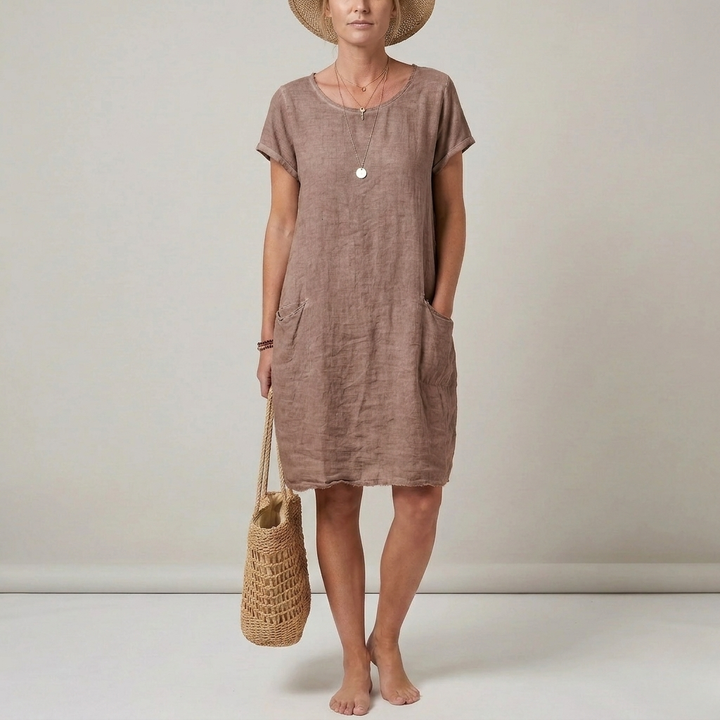Flowy women's shift mini dress with short sleeves and pockets, offering comfortable and casual everyday style.