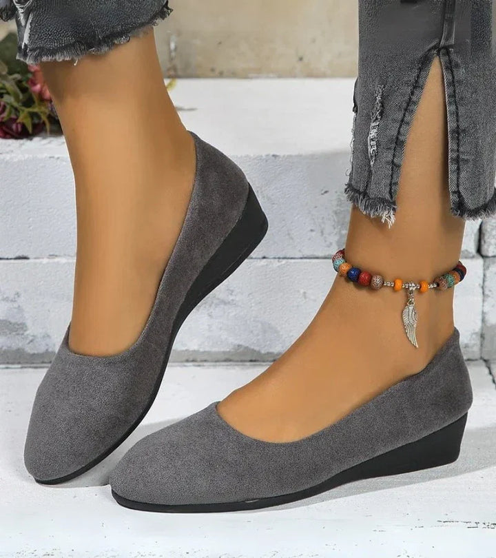 Ladies' comfortable round toe slip-on shoes with a subtle low wedge heel for all-day wear.