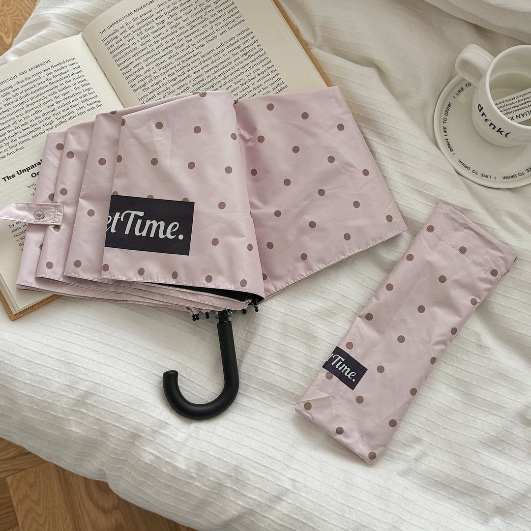 Portable folding umbrella for women, compact polka dot, reliable all-weather protection.