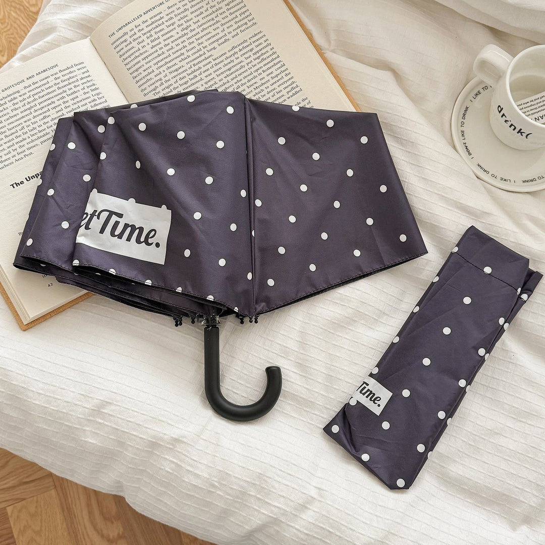 Women's all-weather compact umbrella, stylish polka dot design, easy portability & style.