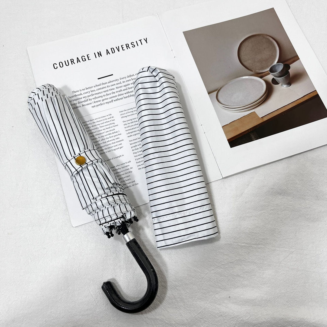 Folding travel umbrella for women, compact polka dot, keeps you dry and stylish in rain.
