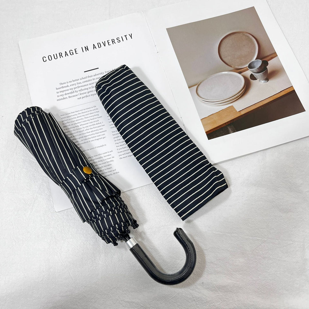 Stylish polka dot women's umbrella, compact folding, essential for travel & daily use.