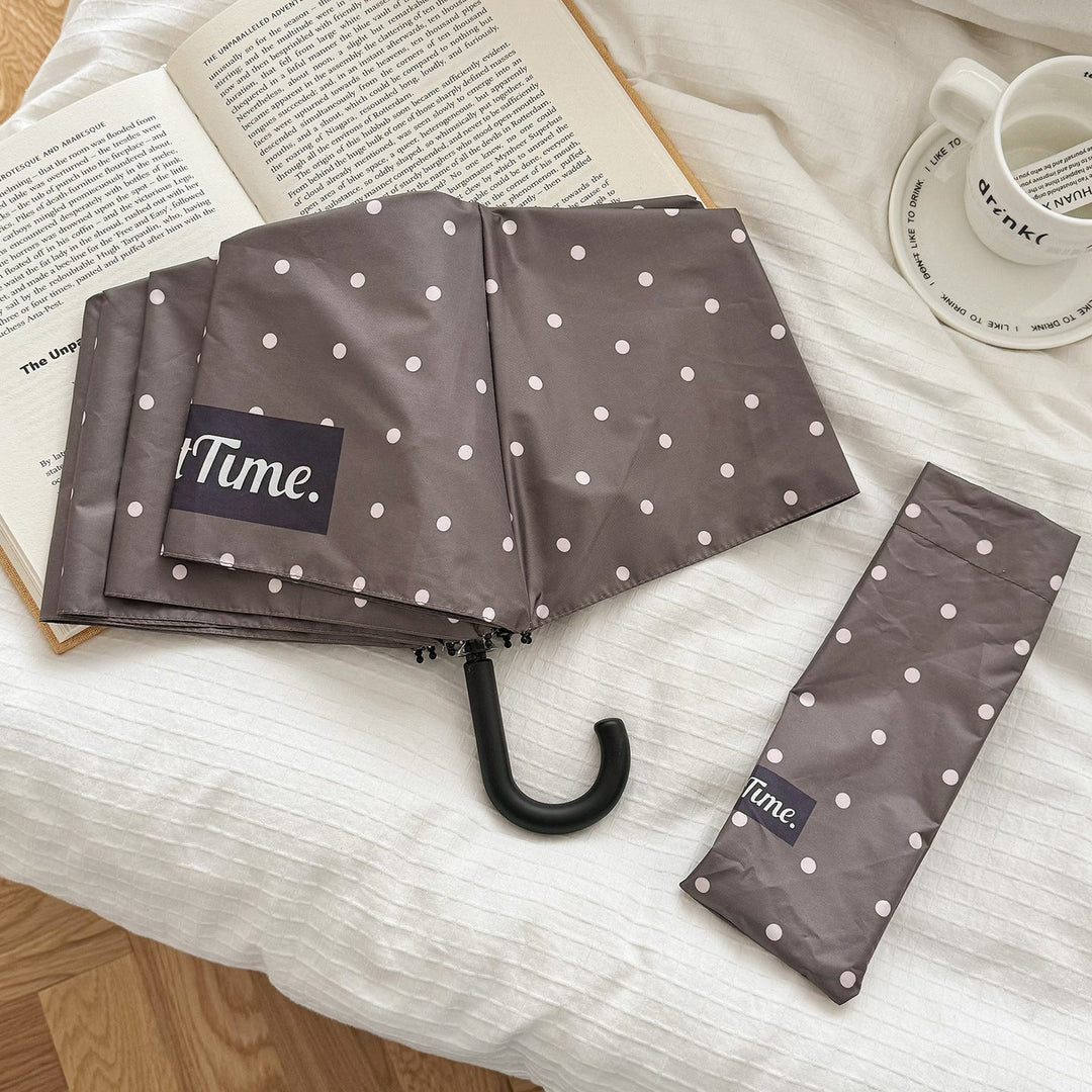 Portable rain gear: Women's compact folding umbrella, chic polka dot design for travel.