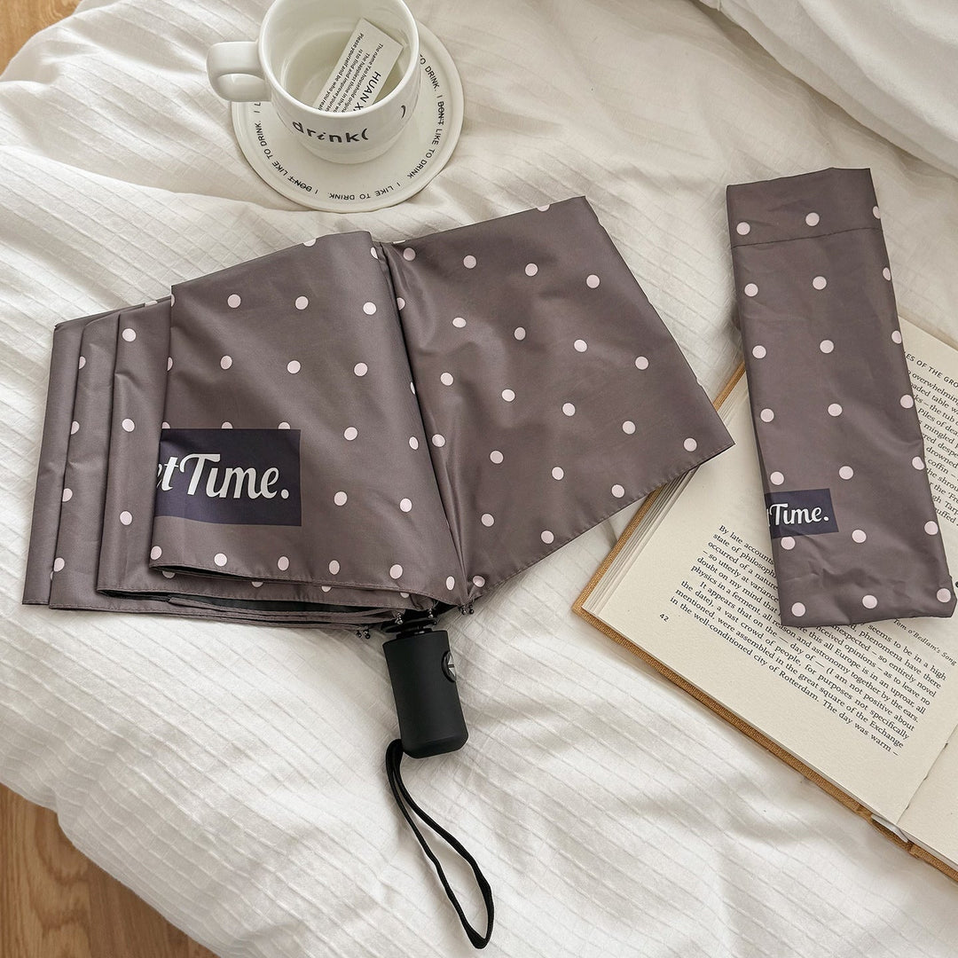 Women's compact folding umbrella, polka dot design, reliable and stylish weather protection.