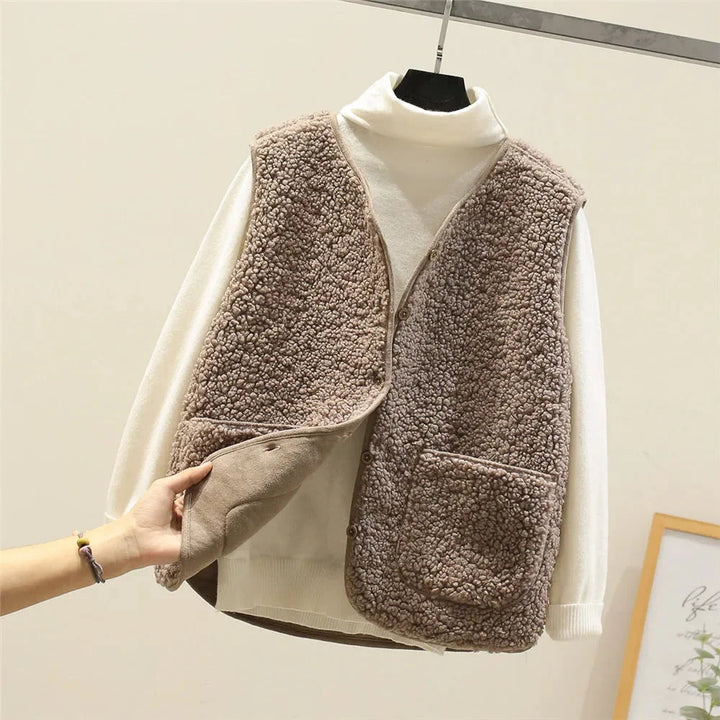 Relaxed fit women's button vest, V-neck style, with two prominent patch pockets. A must-have cozy layer.