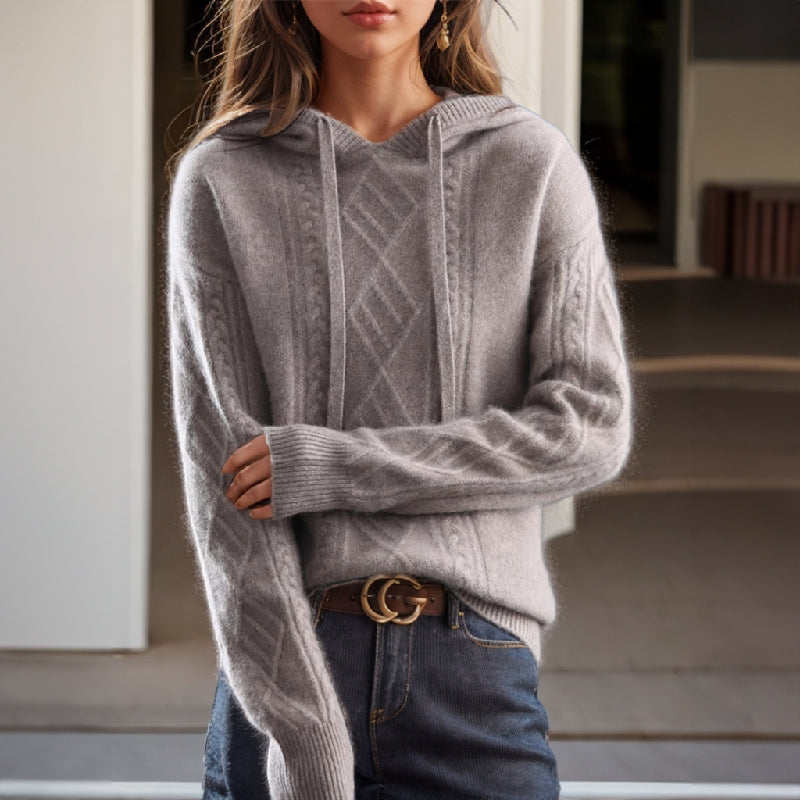 Chic women's cable knit hooded pullover sweater in a relaxed fit. Perfect for cozy, casual winter wear.