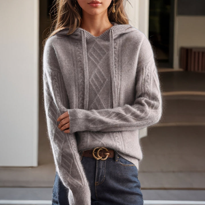 Chic women's cable knit hooded pullover sweater in a relaxed fit. Perfect for cozy, casual winter wear.