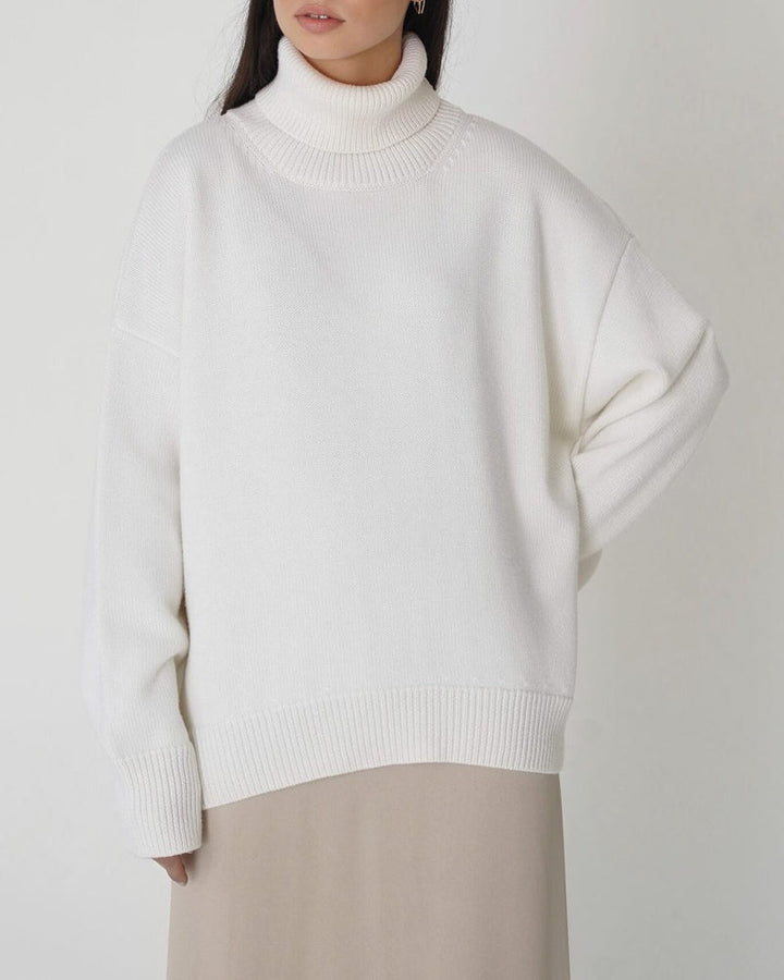 Comfortable women's oversized turtleneck sweater with drop shoulders & ribbed hem. Casual winter fashion.