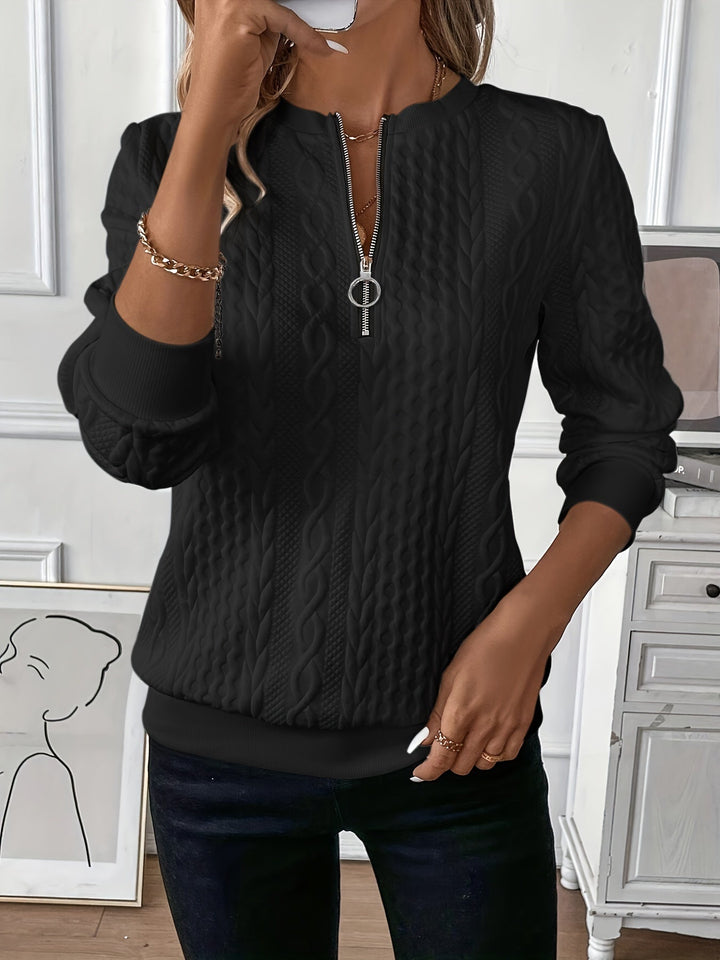 Close-up of women's cozy cable knit zip-up jumper, showing intricate knit texture. Warm winter style.
