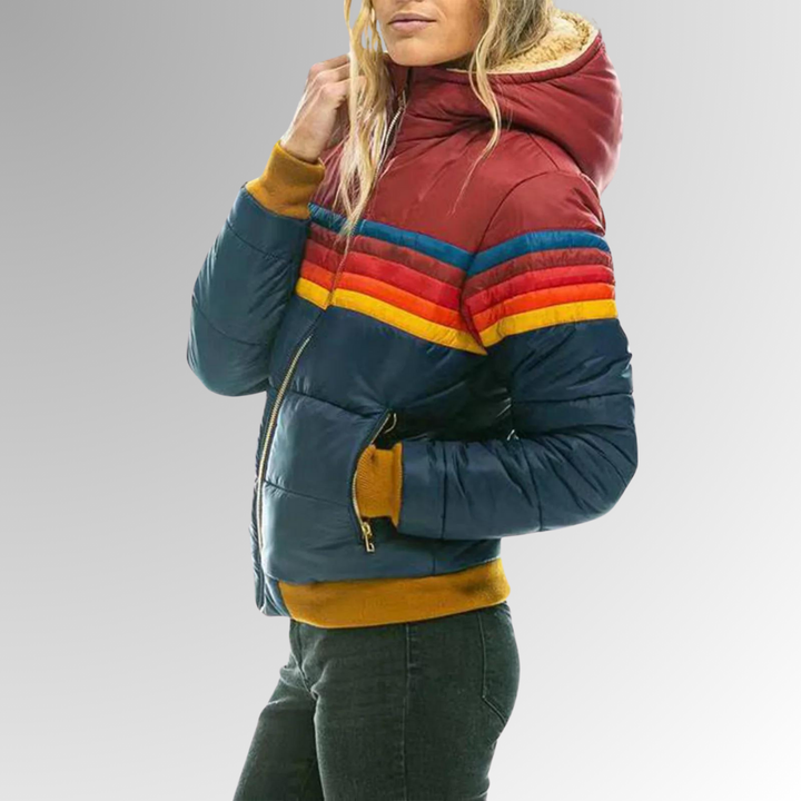 Side view of a blue women's hooded puffer jacket, featuring cozy warmth, deep pockets, & a practical design.