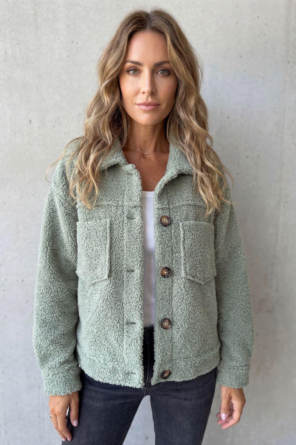 Close-up of women's textured button-up jacket, showcasing stylish buttons & cozy fabric.
