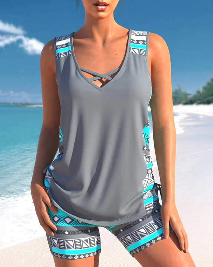 Close-up of women's tankini top featuring criss cross neck and colorful print for summer beachwear.