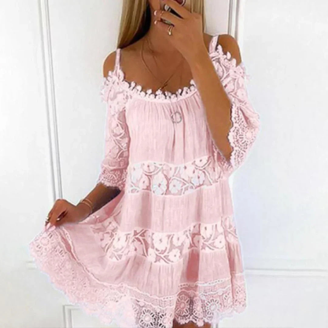Woman wearing a stylish cold shoulder crochet mini dress, ideal for summer beach vacation or a casual day out.