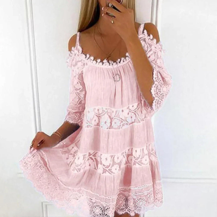 Woman wearing a stylish cold shoulder crochet mini dress, ideal for summer beach vacation or a casual day out.