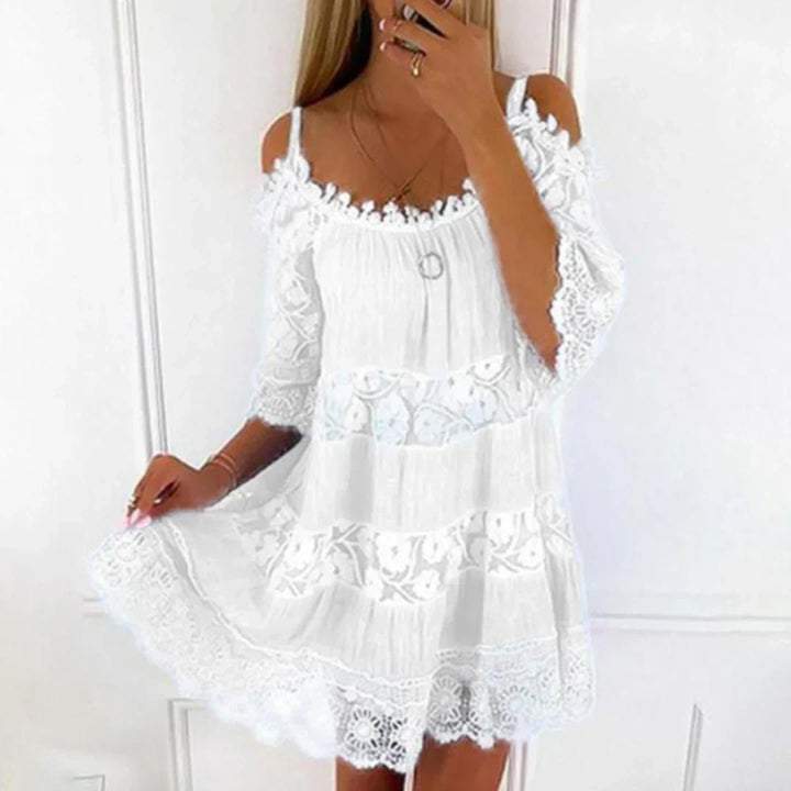 Detailed view of the intricate crochet lace and embroidered pattern on a breezy women's summer mini dress.