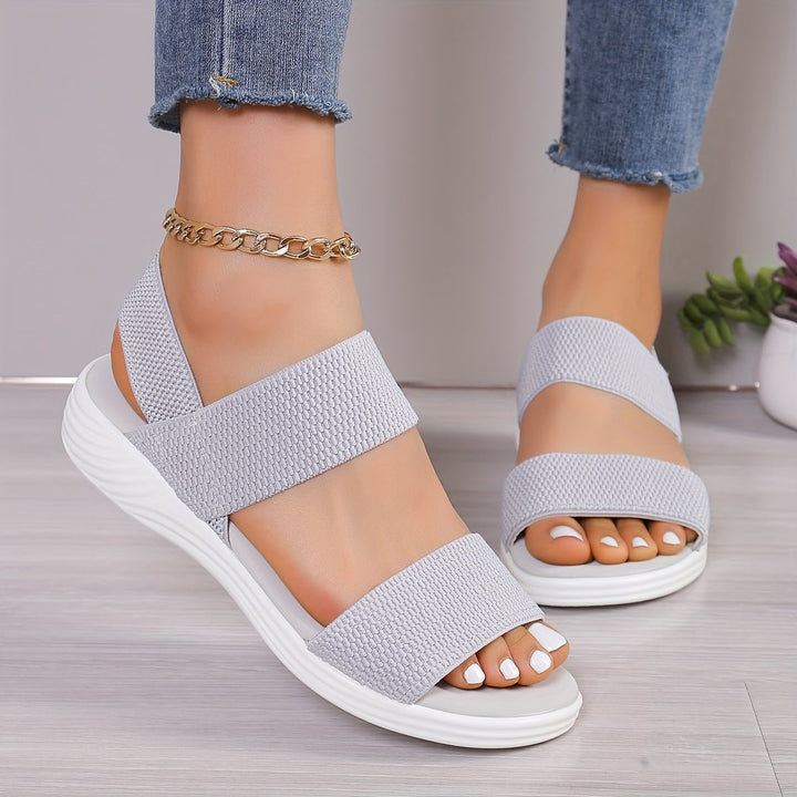 Women's platform sandals with elastic cross-straps & a cushioned sole, providing all-day support & style.