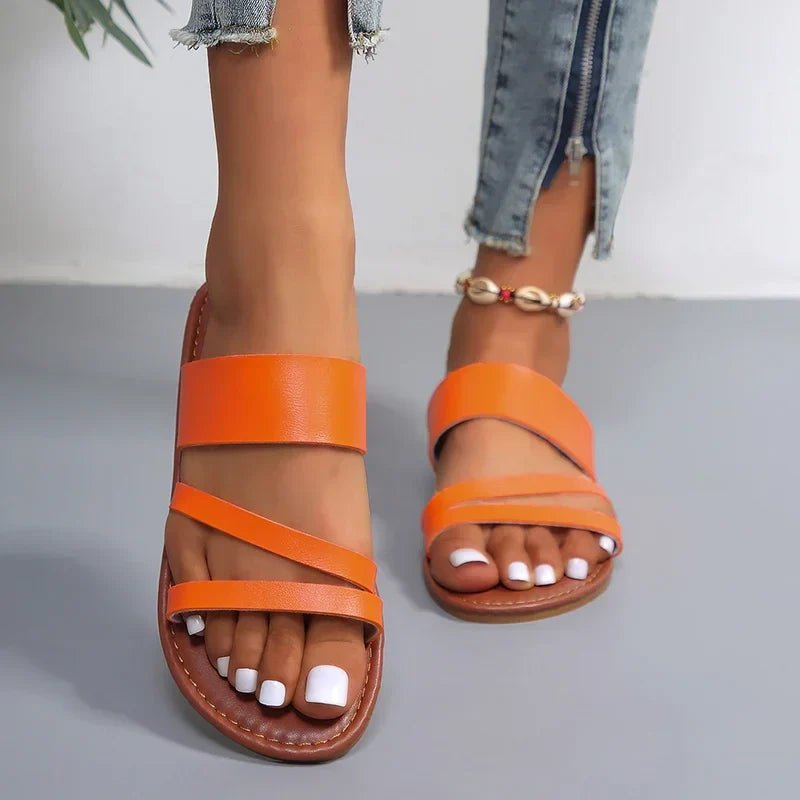Versatile women's flat sandals with cushioned cross-straps, perfect for casual summer slip-on comfort.