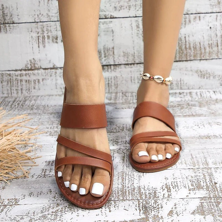 Casual women's cross-strap flat sandals with cushioning, versatile for summer outfits.