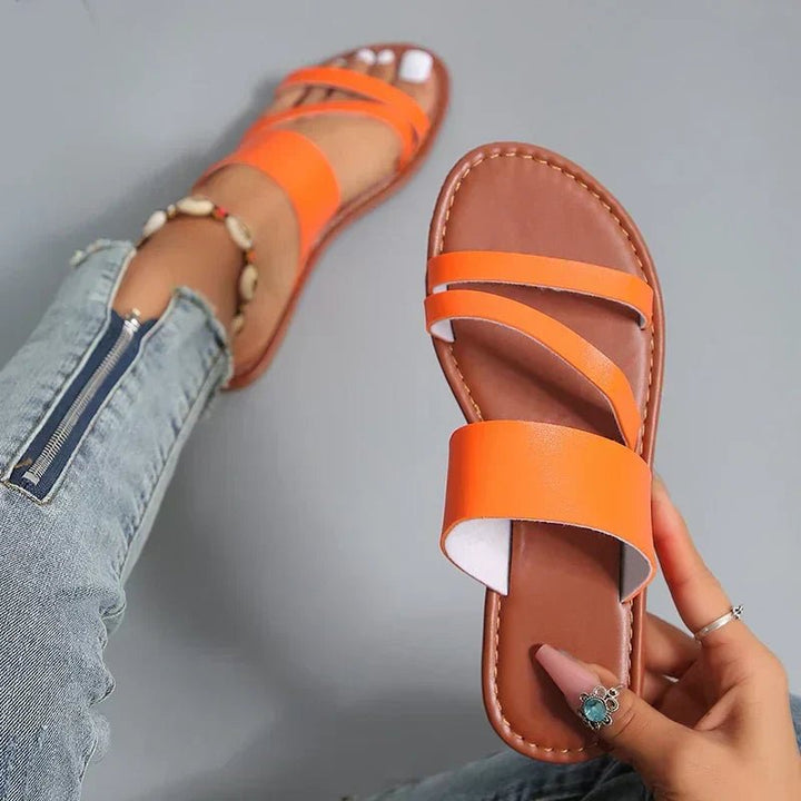 Comfortable women's slip-on sandals featuring soft cross-straps and a cushioned footbed for support.