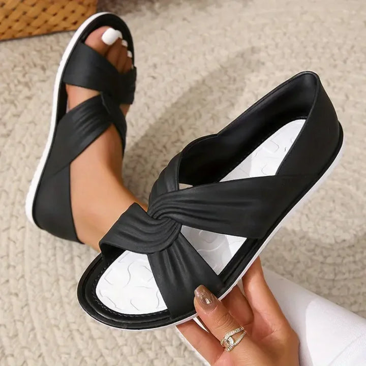 Stylish black women's crossover sandals, open-toe design, great for casual summer outfits.