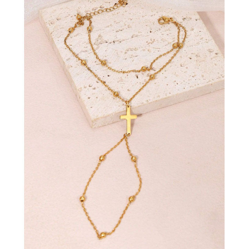 Delicate women's adjustable gold charm bracelet with a subtle cross design, ideal for spiritual fashion.