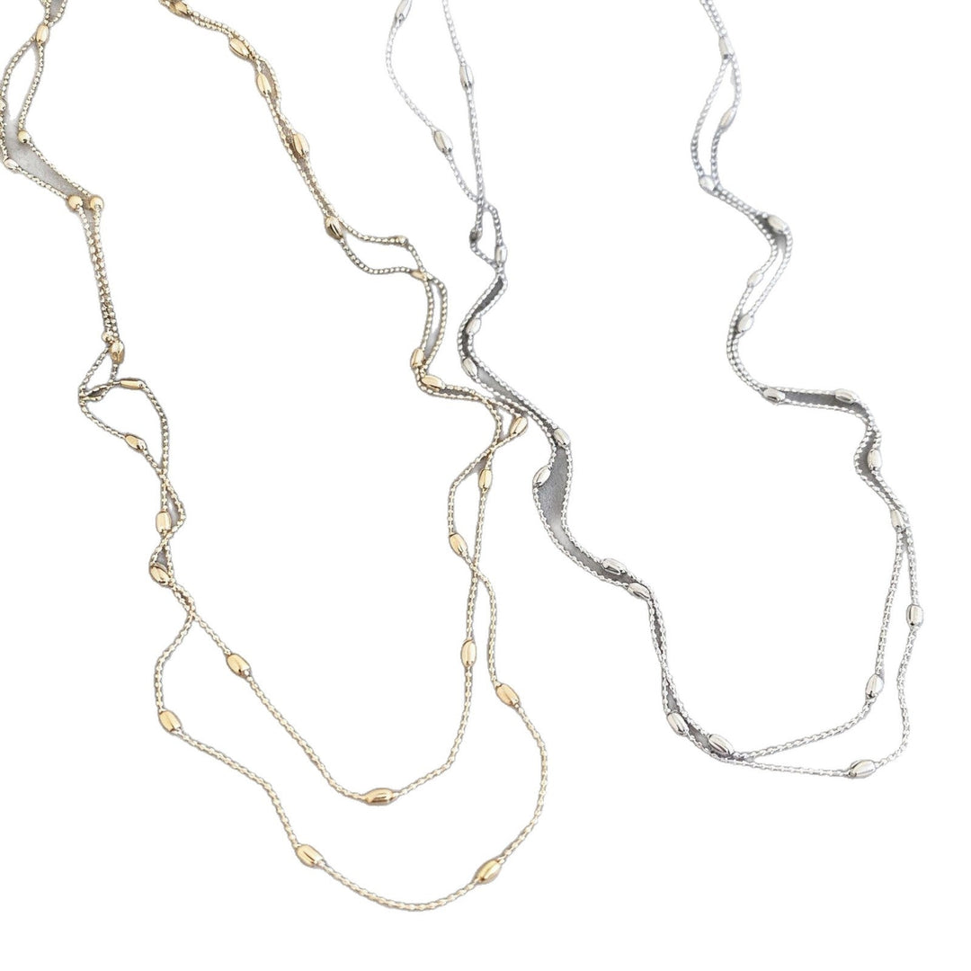 Model wearing a delicate layered gold chain necklace, enhancing her fashion style and jewelry collection.