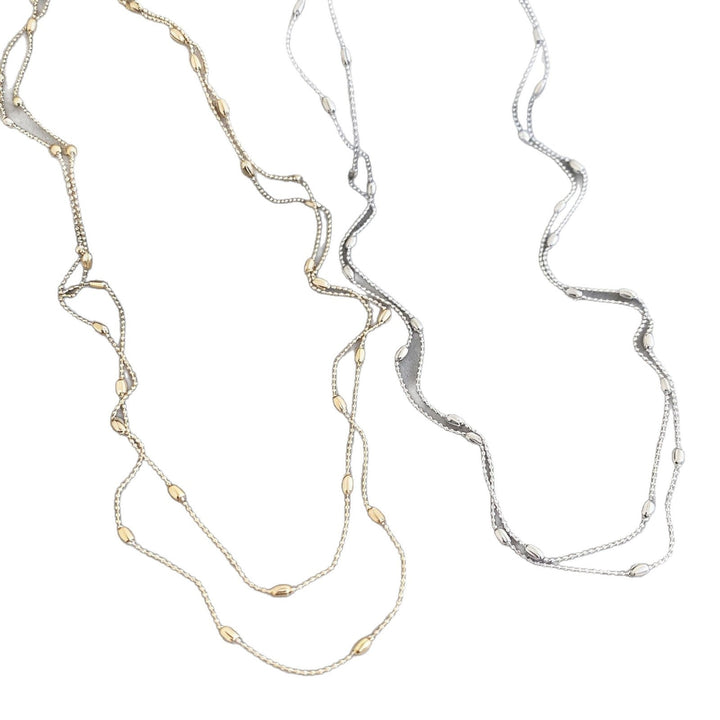 Model wearing a delicate layered gold chain necklace, enhancing her fashion style and jewelry collection.