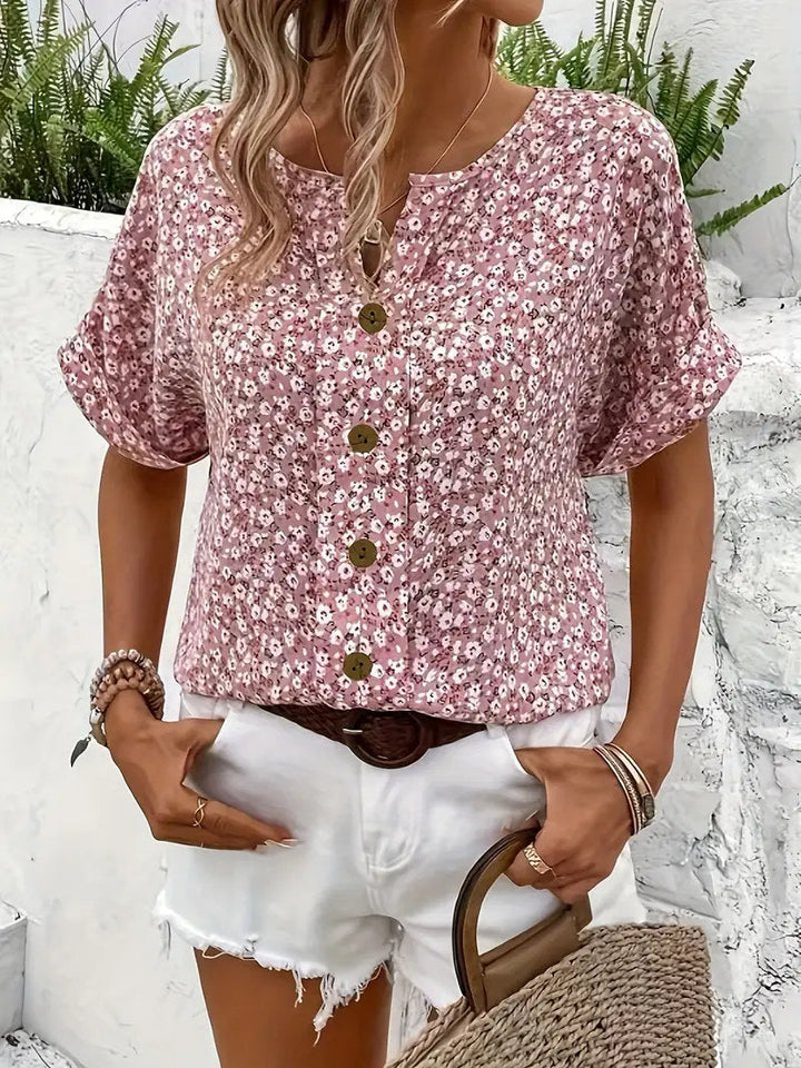 Feminine ditsy floral print blouse for women, featuring a button-front, short sleeves, and relaxed fit for comfort.