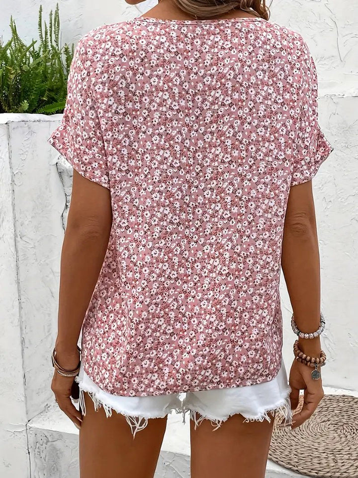 Elegant women's ditsy floral blouse with short sleeves, a relaxed fit, and a classic button-front design for summer.