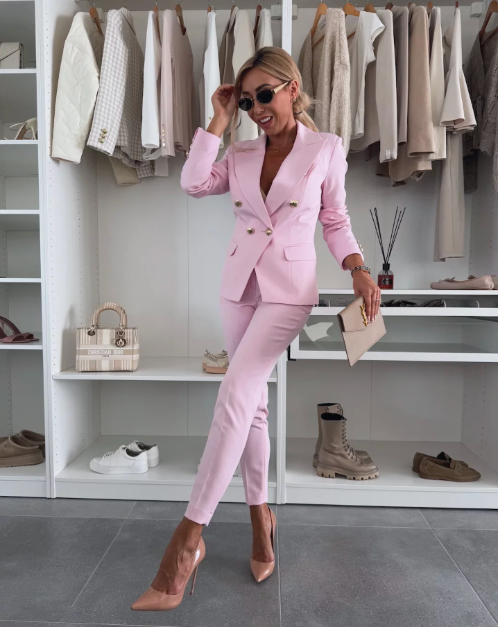 Full-length shot of a women's formal two-piece suit. Tailored double-breasted blazer & slim trousers.