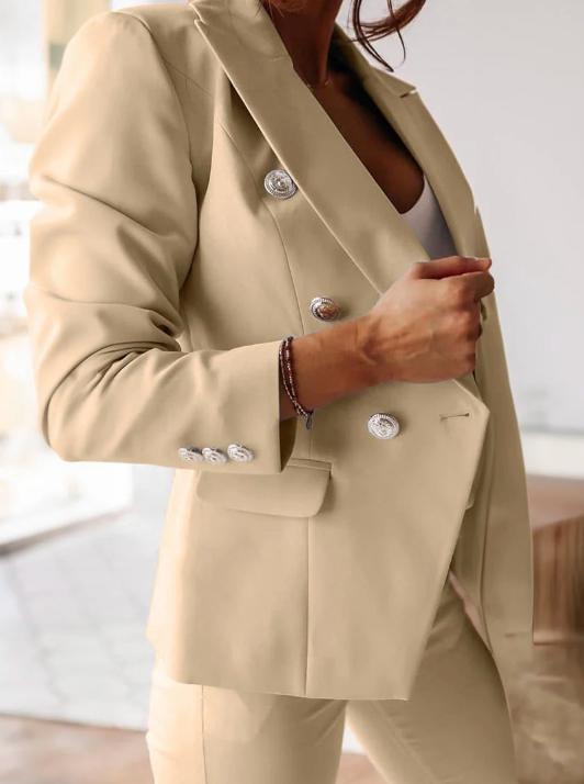 Rear view of a women's chic tailored suit. Double-breasted blazer & well-fitting slim trousers.
